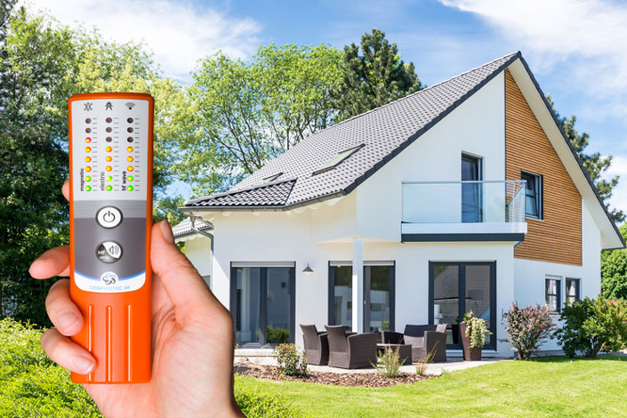 Das Messgerät Cemprotec34 misst Elektrosmog im Garten eines Einfamilienhauses.