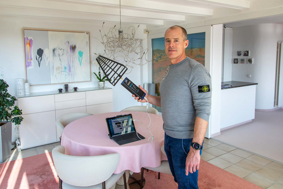 Ein Messtechniker mit einem Messgerät für elektromagentische Strahlung in der Hand.